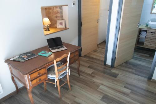 a desk with a laptop on it in a room at Le Clos du Barry in Sévérac-lʼÉglise
