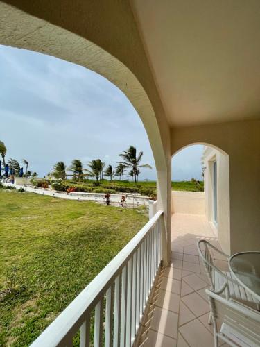 a balcony with chairs and a view of the beach at Northwest Point Resort in Wheeland Settlement