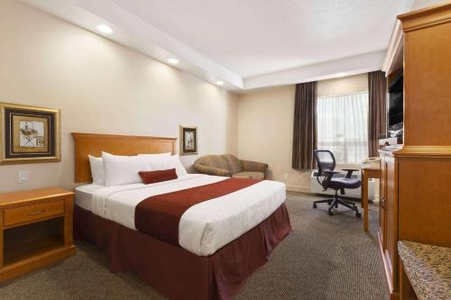 a hotel room with a bed and a desk at Travelodge by Wyndham Spruce Grove in Spruce Grove