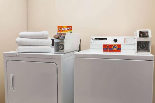 a laundry room with a refrigerator and a microwave at Travelodge by Wyndham Spruce Grove in Spruce Grove