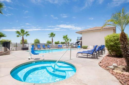 a pool with blue chairs and a swimming pool at Days Inn by Wyndham Lake Havasu in Lake Havasu City