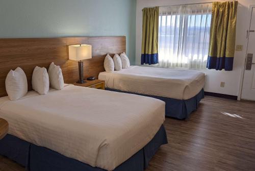 a hotel room with two beds and a window at Days Inn by Wyndham Lake Havasu in Lake Havasu City