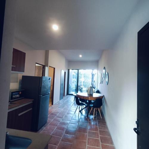 a kitchen with a table and a refrigerator at Lago San Cristóbal Suites in San Cristóbal Zapotitlán