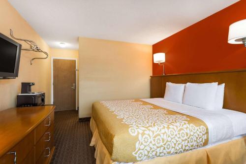 a hotel room with a bed and a flat screen tv at Days Inn by Wyndham Chincoteague Island in Chincoteague