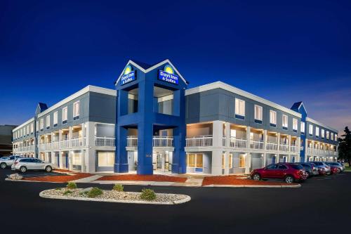 a large office building with a parking lot at Days Inn & Suites by Wyndham Warren in Warren