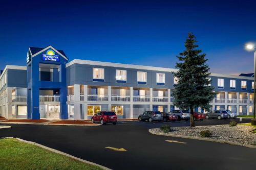a large building with cars parked in a parking lot at Days Inn & Suites by Wyndham Warren in Warren