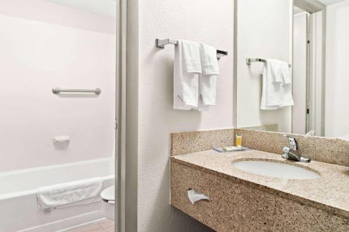 a bathroom with a sink and a mirror at Days Inn & Suites by Wyndham Warren in Warren