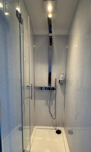 a shower with a glass door in a bathroom at Hartcliffe Retreat in Penistone