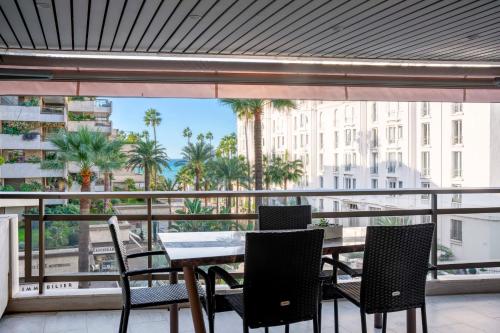 une table et des chaises sur un balcon avec vue sur une ville dans l'établissement REF 1924 - Cannes Croisette - Sea view apartment for rent, à Cannes