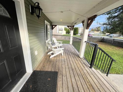 a porch with two white benches on a house at King and Queen rooms -J&J Chilliwack in Chilliwack
