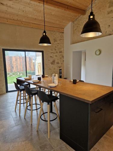 une cuisine avec une grande île et des fauteuils de bar dans l'établissement Maison agréable en pierre, à Montagne