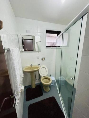 a bathroom with a toilet and a sink and a shower at Casa pé na areia praia Garopaba in Garopaba
