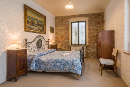 a bedroom with a bed and a table and a chair at Agriturismo Santa Croce in San Gimignano