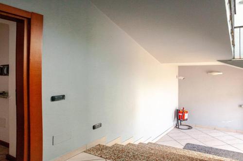 a room with a white wall with a fire extinguisher at A Home away From Home By Alex in Busto Arsizio