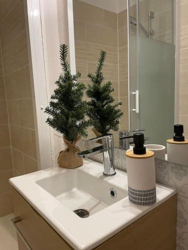 La salle de bains est pourvue d'un lavabo avec deux arbres. dans l'établissement Grand T2 centre ville proche pistes ski et thermes, à Luchon