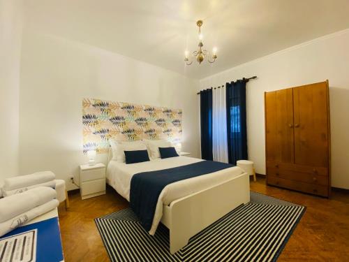 a bedroom with a king sized bed and a couch at Alojamento CANTO NA RELVA in Ponta Delgada