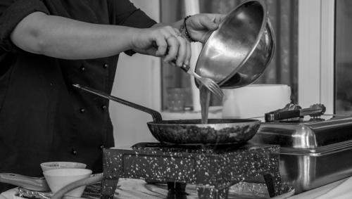 a person is cooking in a bowl in a kitchen at Oasis Beach Hotel in Skala