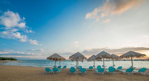 a group of chairs and umbrellas on a beach at Oasis Beach Hotel in Skala