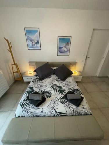- une chambre avec un lit et une couette blanche et noire dans l'établissement Appartement T2 cosy - Embrun, à Embrun