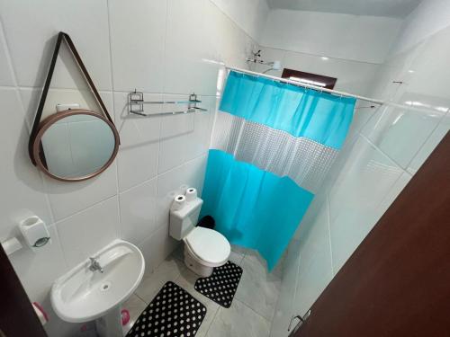 a bathroom with a toilet and a sink and a mirror at Tranquilidade e água fresca! in Tramandaí