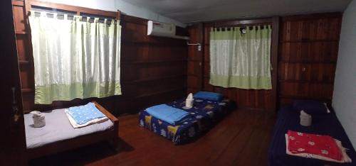a room with two beds and two windows at Lungmin homestay in Mae Hong Son