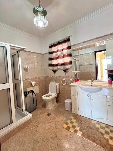 a bathroom with a toilet and a sink and a tub at Blue Paradise Apartment in Ribeira Brava