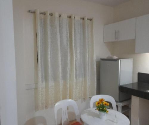 a kitchen with a table and two white chairs and a window at Staycation! Daily, weekly, monthly! in San Fernando