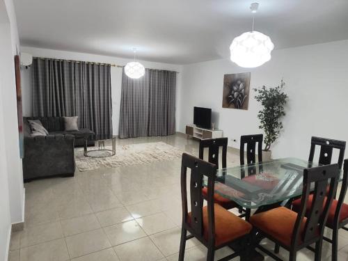 New cairoにある3 bedrooms apartment in Al Rehab cityのガラスのテーブルと椅子のあるリビングルーム