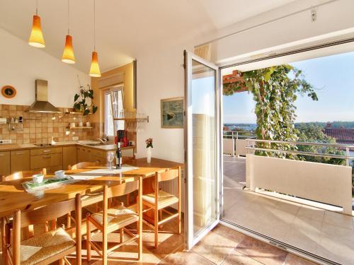 a kitchen with a wooden table and a balcony at Apartments Ceja near sea in Medulin