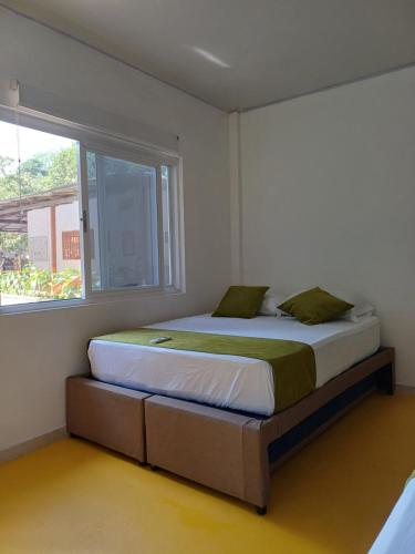 a bed in a room with a large window at Finca LA CASCADA in Mesa del Norte