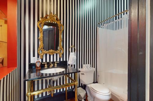 a bathroom with a sink and a mirror and a toilet at Anderson Place in Savannah