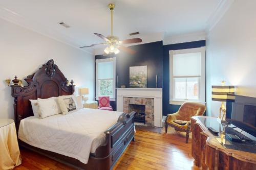 a bedroom with a bed and a tv and a fireplace at Anderson Place in Savannah