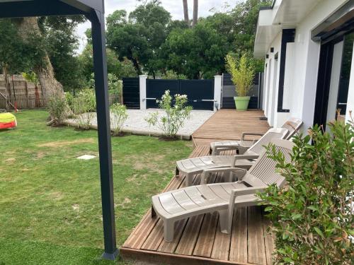 a group of chairs sitting on a wooden deck at villa bord de mer 400 M de la plage in Labenne
