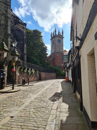 an empty street with a clock tower in the distance at Cosy Studio - Town centre flat with free nearby parking in Shrewsbury