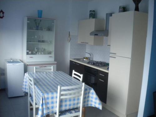 a small kitchen with a table and a refrigerator at Casa Vacanza Azzurra 2 in Fano