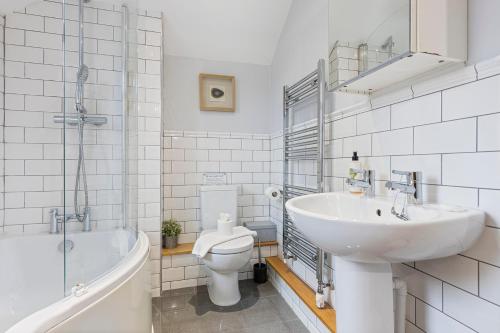 a bathroom with a sink and a toilet and a tub at No 1 - Laurel Cottage - Pass the Keys in York
