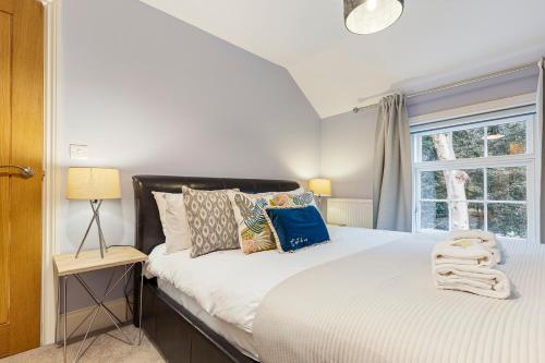a bedroom with a bed with pillows and a window at No 1 - Laurel Cottage - Pass the Keys in York