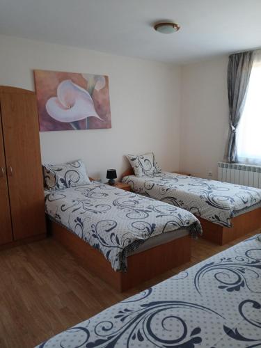 a room with two beds and a painting on the wall at Guest rooms Bansko in Bansko