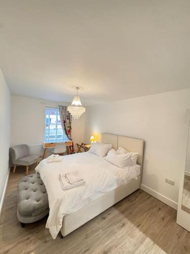 a bedroom with a large white bed and a chair at Gorgeous 2 bed apartment with free parking near, Sefton Park, Palm House, Lark Lane, Liverpool and Everton football clubs in Liverpool