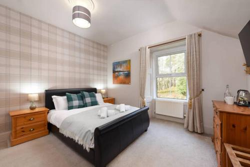 a bedroom with a large bed and a window at Strathardle Lodge in Kirkmichael