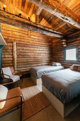 a bedroom with two beds in a wooden cabin at ÖBois Charlevoix - L'Écurie 4 Studio in Saint-Siméon
