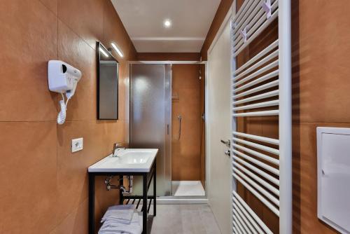 un baño con lavabo y ducha en Apho Apartment Hotel, en Rímini