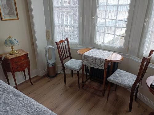 a room with a table and chairs and a bed at Villa des Chats in Calais