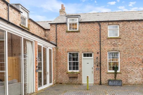 a brick house with a white door and windows at No 3 - Lime Tree Cottage - Pass the Keys in York