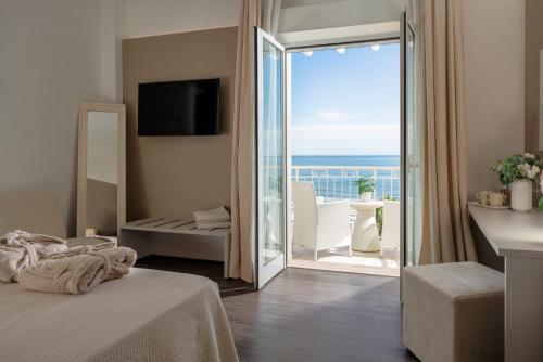 a bedroom with a large sliding glass door to a balcony at Hotel Ca' Bianca in Riccione
