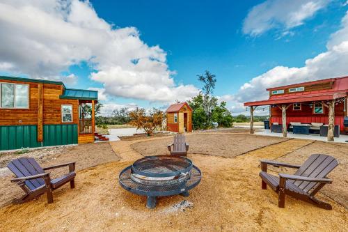 a patio with two chairs and a table and two buildings at Cabins on the Ranch in Harper