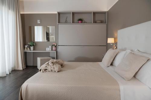 a bedroom with a large white bed with white pillows at Hotel Ca' Bianca in Riccione