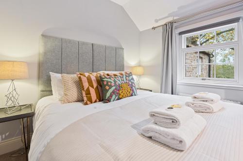 a bedroom with a large white bed with towels on it at No 4 - Oak Tree Cottage - Pass the Keys in York