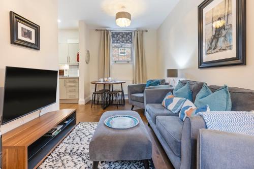 a living room with a couch and a flat screen tv at No 4 - Oak Tree Cottage - Pass the Keys in York