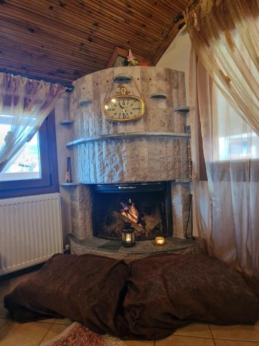 a bedroom with a fireplace and a clock on the wall at Guest house Elatochori in Elatochori